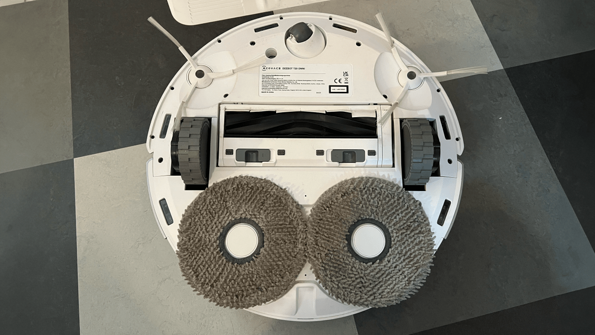 Undersidan av Deebot T20 Omni. En gummiborste i mitten, två små borstar fram på varje sidas om vispar in smuts i mitten och två runda moppar bak.